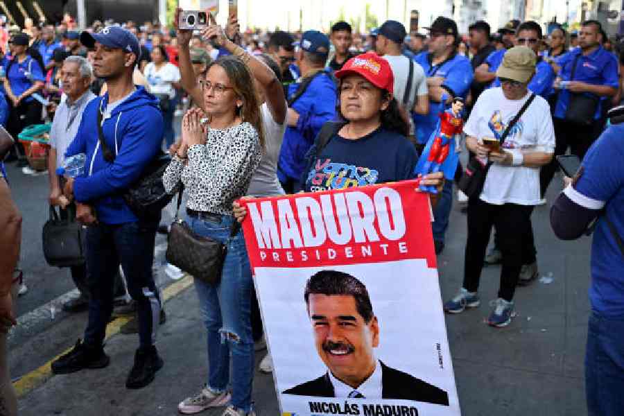 A protester holds a sign with an image of Nicolás Maduro outside the National Assembly in Caracas on Monday.