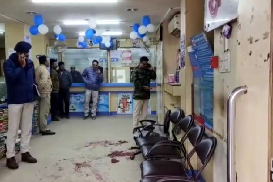 Police inspect the bank in Bidhannagar, Siliguri, where a guard's firearm was accidentally discharged on Tuesday