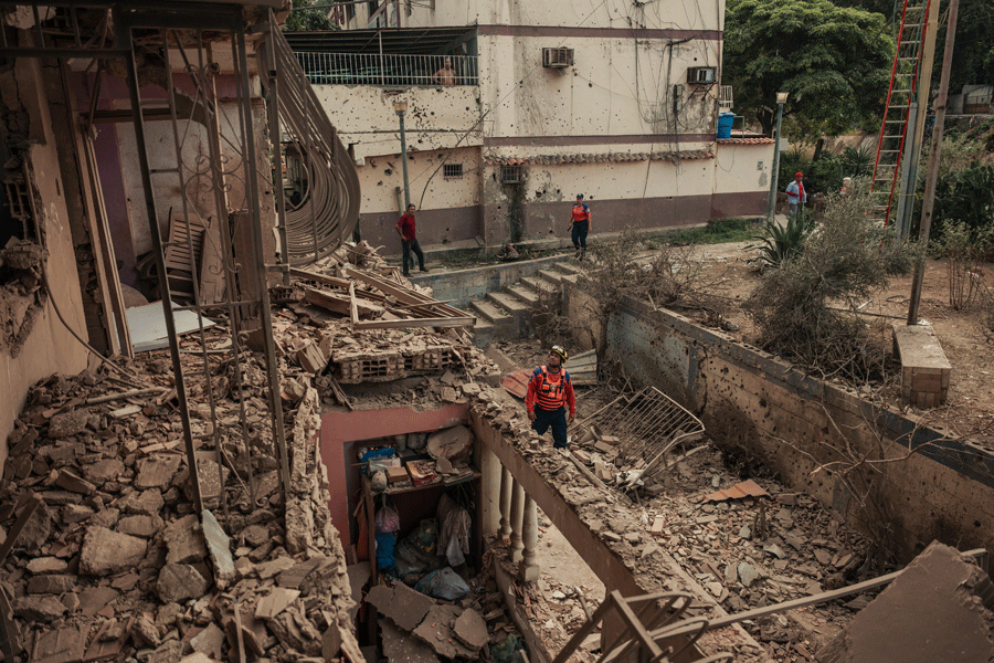 Civil defense workers and local residents survey the damage to an apartment building damaged in a U.S. air strike in Catia La Mar, a town in La Guaira state outside Caracas, Venezuela, on Saturday, Jan. 3, 2026. The mission to seize Nicolas Maduro also resulted in the deaths of about 40 Venezuelans, in addition to 32 Cubans who were helping to guard Maduro, according to Venezuelan and Cuban officials.