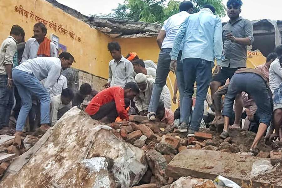 Locals during the rescue work after a government school building collapsed, in Jhalawar district, Rajasthan, Friday, July 25, 2025.
