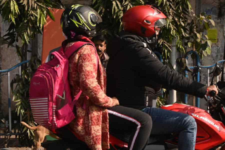 Commuters on a motorbike wrapped in woollens in Esplanade on Thursday afternoon