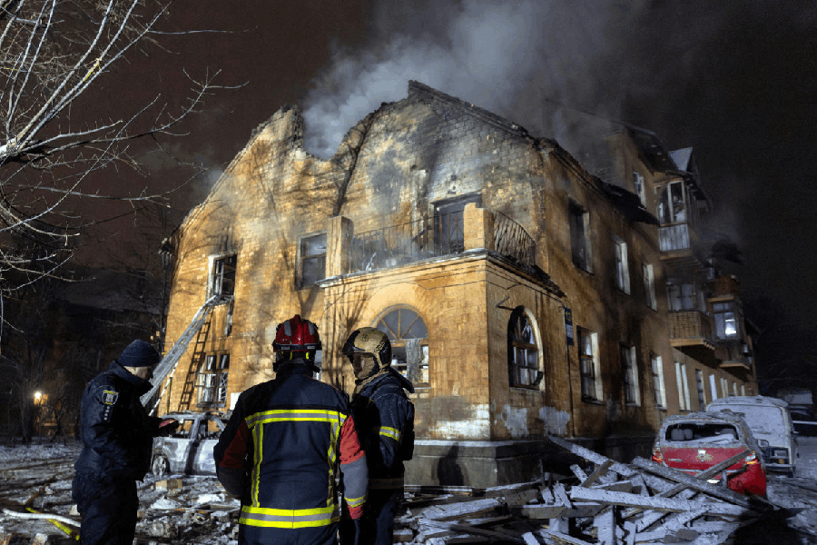 Firefighters stand in front of a residential building that was hit during a night of Russian drone and missile attacks, amid Russia's attack on Ukraine, in Kyiv, Ukraine, January 9, 2026.