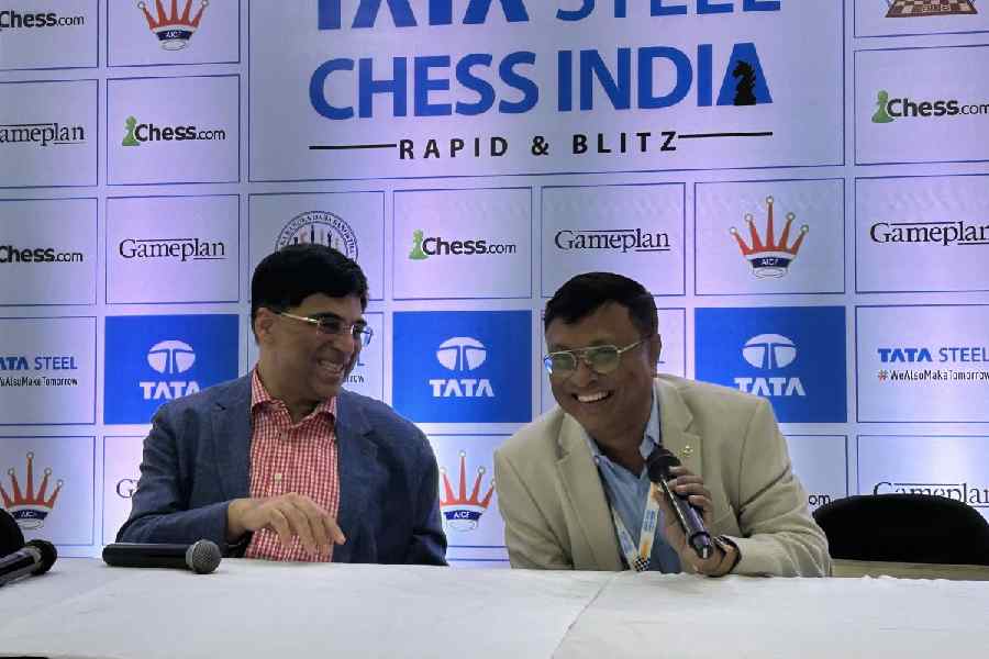 Viswanathan Anand (left) shares a light moment with Tata Steel Chess India tournament director Dibyendu Barua before Friday's news conference at Dhono Dhanyo Auditorium. 
