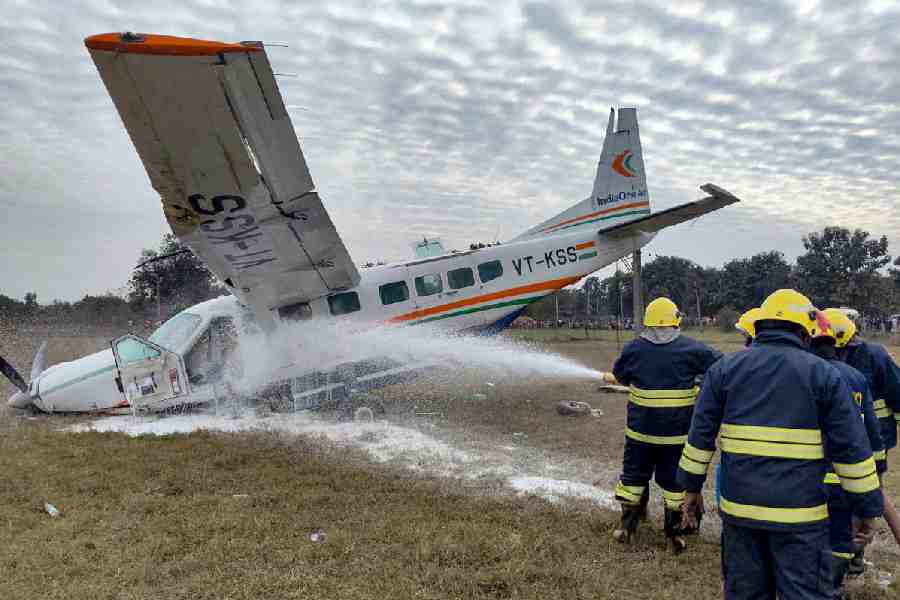 Firefighters douse a fire after a small aircraft carrying four passengers and two crew members crashed at Raghunathpali area, in Rourkela, Odisha.