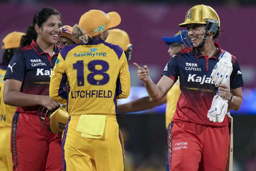 Royal Challengers Bengaluru's captain Smriti Mandhana, right, and Richa Ghosh, left, being congratulated by UP Warriorz's Phoebe Litchfield after winning the Women's Premier League (WPL) T20 cricket match between Royal Challengers Bengaluru and UP Warriorz, at the DY Patil Stadium in Navi Mumbai