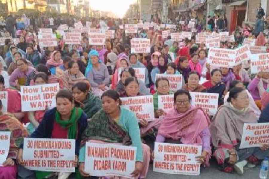 Internally displaced persons hold up placards during the protest in Imphal on Monday