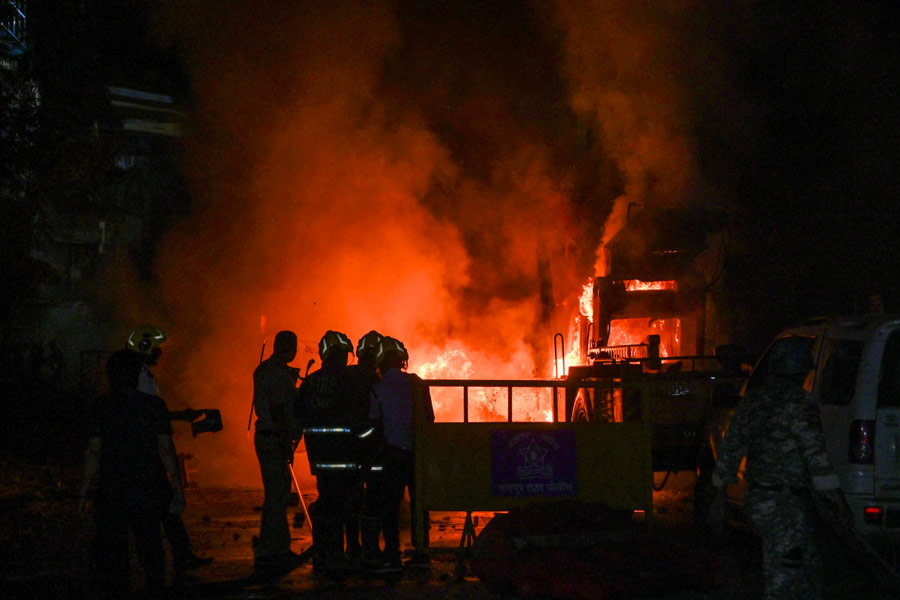 FILE PHOTO: Members of police stand as vehicles burn after clashes erupted due to demands over removal of the tomb of Mughal emperor Aurangzeb, in Nagpur