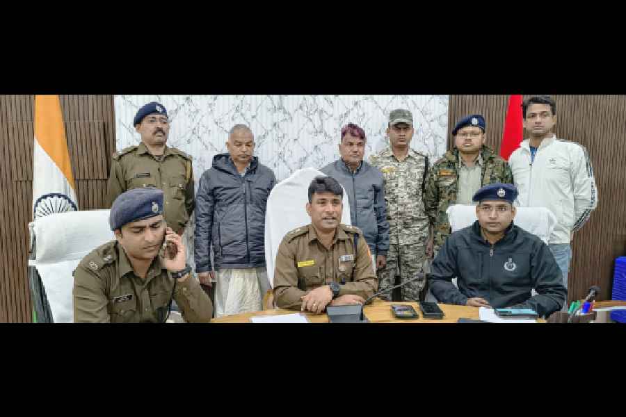 Malda SP Avijit Banerjee (centre) speaks to the media about the arrests of narcotics kingpin Enarul Sheikh (standing, in dark grey hoodie) and his associate Sowkat Sheikh (standing, in grey jacket) on Tuesday. 