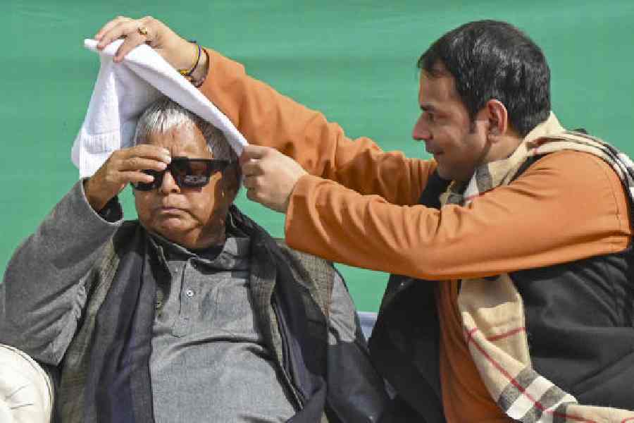 Lalu Prasad with Tej Pratap Yadav at his elder son’s Makar Sankranti feast in Patna on Wednesday. 