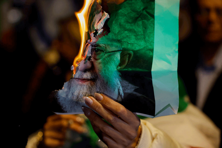 A woman holds a burning picture of Iran's Supreme Leader Ayatollah Ali Khamenei, as Israelis rally in support of the nationwide protests happening in Iran, in Holon, Israel, January 14, 2026.