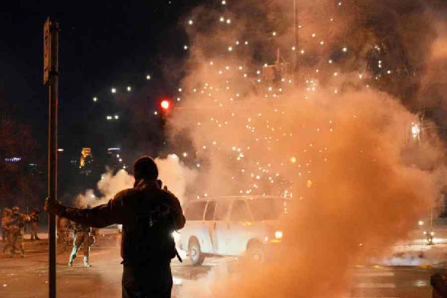 A person stands near tear gas smoke in north Minneapolis on Wednesday. 
