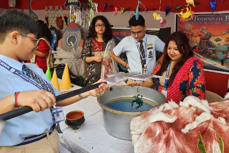 A St Francis Xavier student fishes out a toy crab with "Poseidon’s trident".