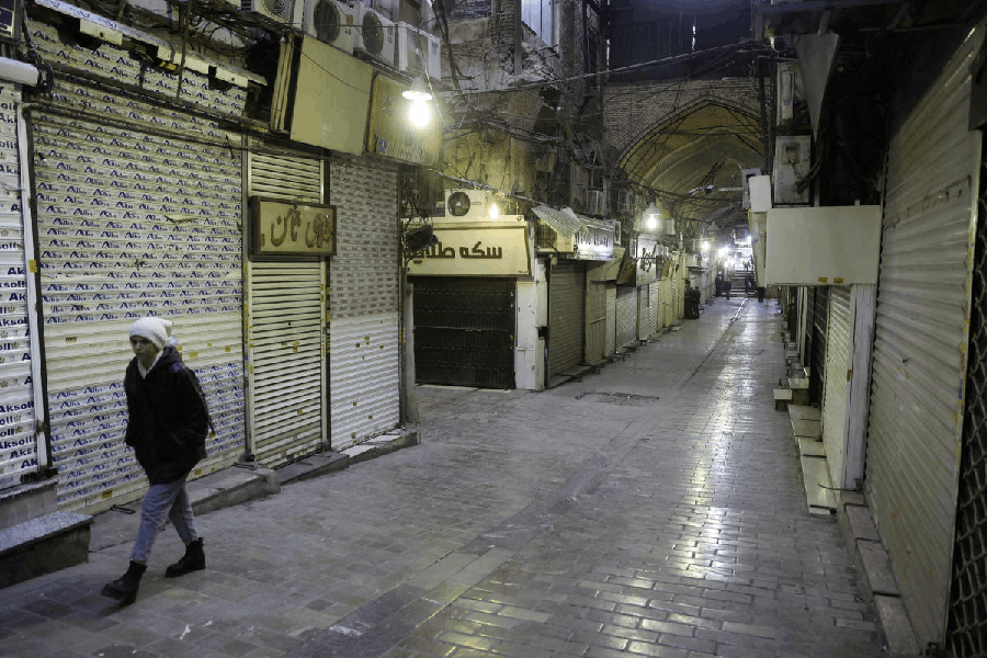 People walk past closed shops, following protests over a plunge in the currency's value, in the Tehran Grand Bazaar in Tehran, Iran.