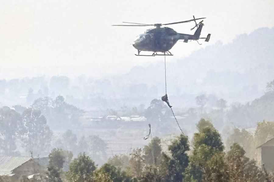 A security official rappels from a helicopter during an operation targeting UKNA camps in Churachandpur on Friday.