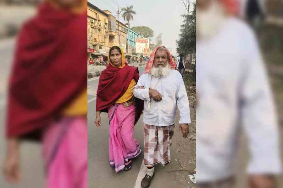 Ailing Murtaj Sheikh walks with his wife on a stretch of Murshidabad’s Behrampore town on Saturday as the bus stand was shifted because of Abhishek Banerjee’s road show. Picture by Samim Aktar