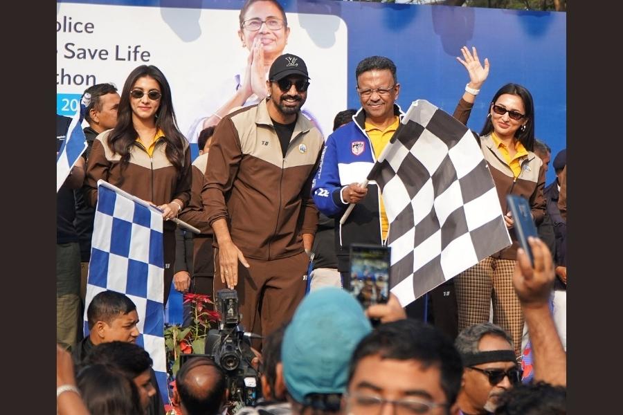 Actors Rukmini Maitra, Dev Adhikari and Mimi Chakraborty flank Mayor Firhad Hakim, waving chequered flags 