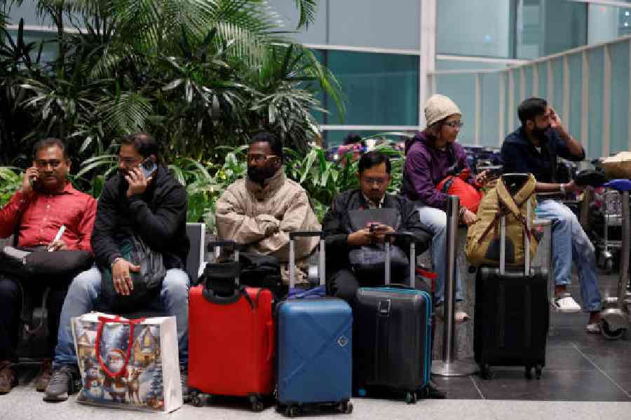 Travellers wait at Delhi airport on December 5 after several flights were cancelled