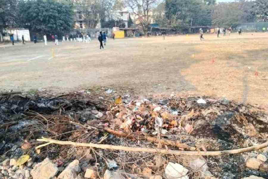 Waste set ablaze inside Vivekananda Park while local youth attended cricket coaching camps on Saturday morning. Picture by Subhajoy Roy 