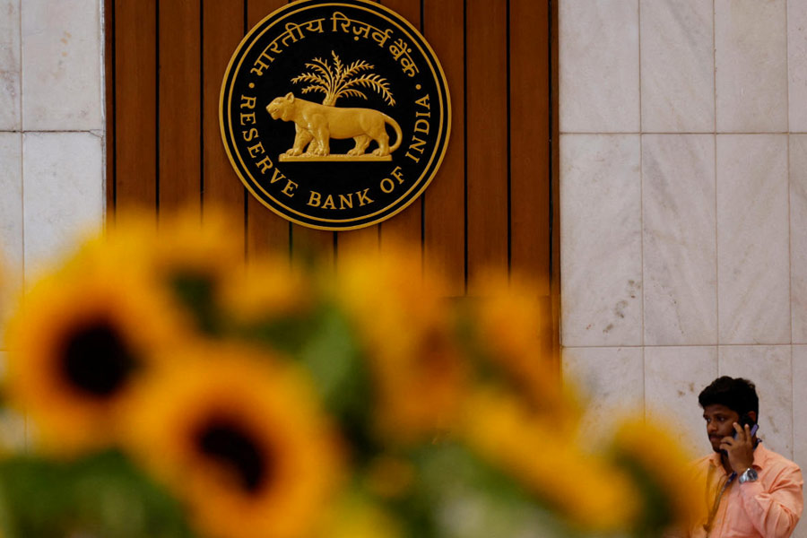 File Photo: A man speaks on his phone as he walks past the Reserve Bank of India (RBI) logo inside its headquarters in Mumbai, India, February 7, 2025.