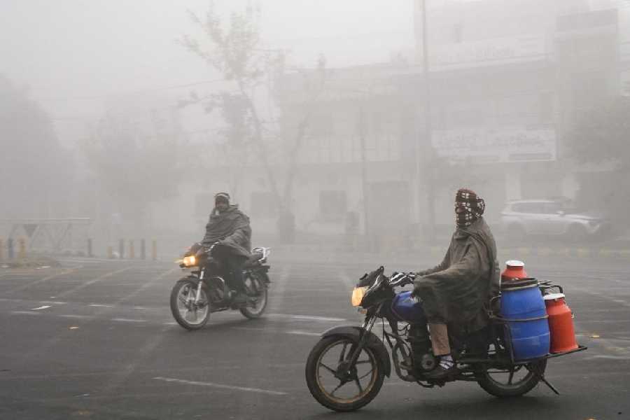 Commuters make their way during a cold and foggy winter morning, in Amritsar