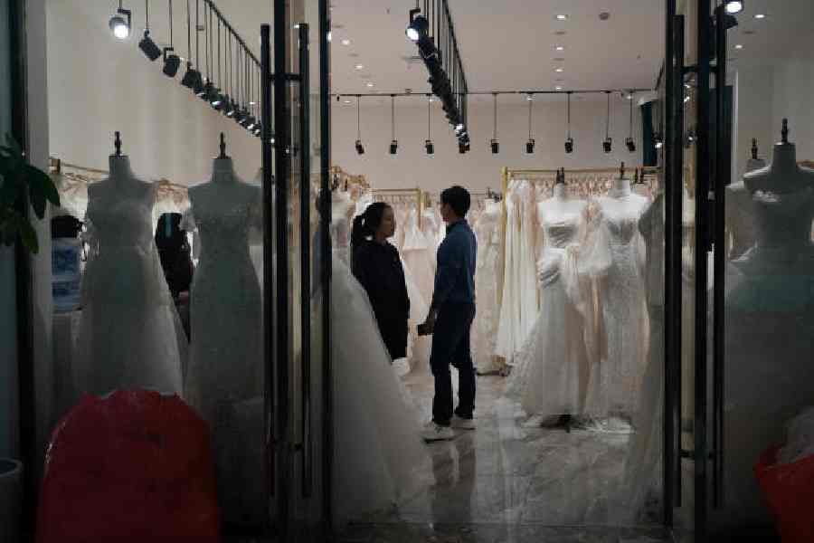 A couple shops for a wedding gown at Huqiu Bridal City in Jiangsu province, China, on Friday. 