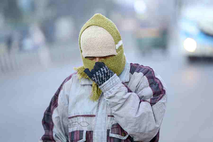A man walks on a road wearing woollen clothes on a cold winter morning, in Ranchi, Tuesday, Dec. 30, 2025.