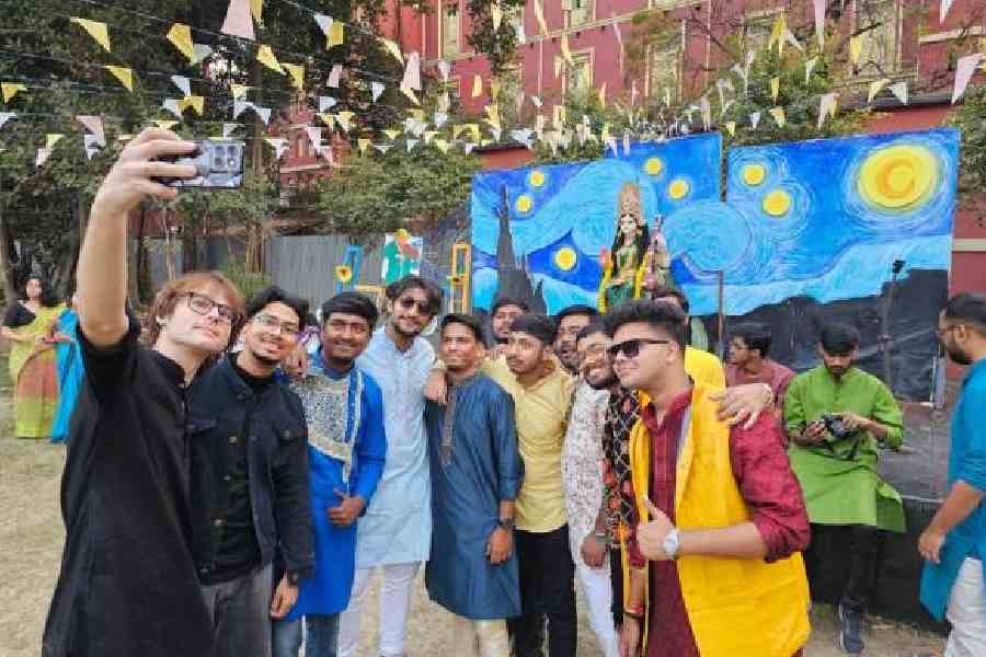 Boarders click a picture in front of the Saraswati idol at the Eden Hindu Hostel on Friday. Picture by Sudeshna Banerjee