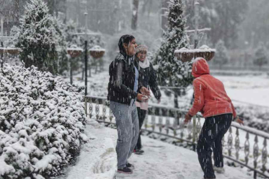 Tourists enjoy the snowfall in Mussoorie, Uttarakhand, on Friday.