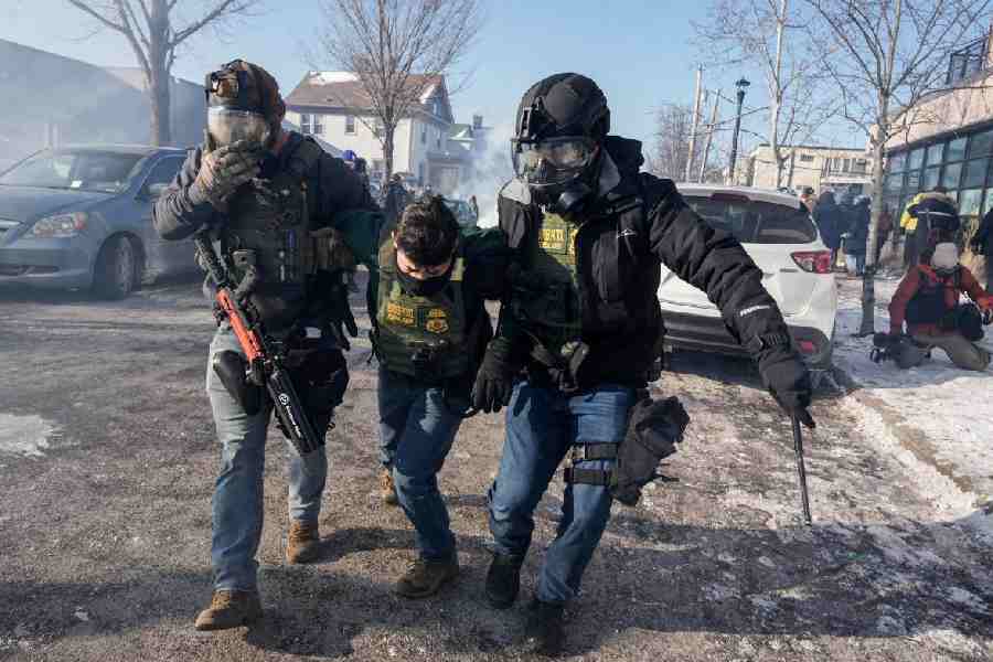 Federal agents carry away a colleague during scuffles at the scene of a shooting involving federal immigration agents in Minneapolis
