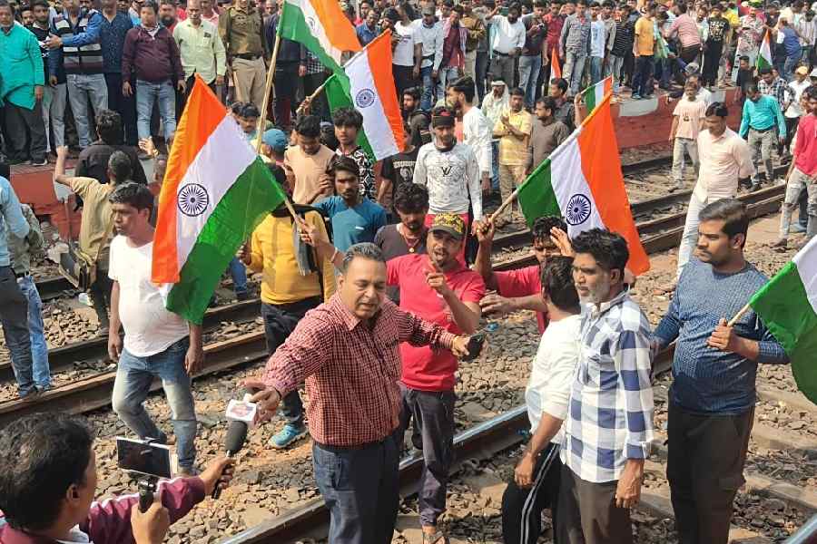 People block the tracks at the Burdwan railway station in protest against the alleged harassment in the name of the SIR on Saturday. 