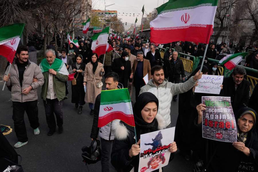 People carry Iranian flags and pro-government placards during a funeral ceremony for a group of security forces, who were killed during anti-government protests, in Tehran, Iran, Wednesday, Jan. 14, 2026.
