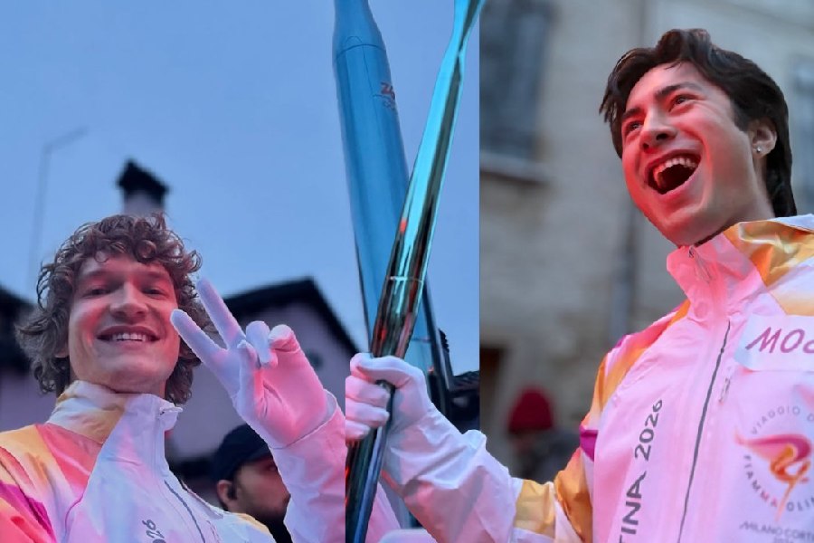 Hudson Williams (right), Connor Storrie (left) and carry the Olympic torch in Italy