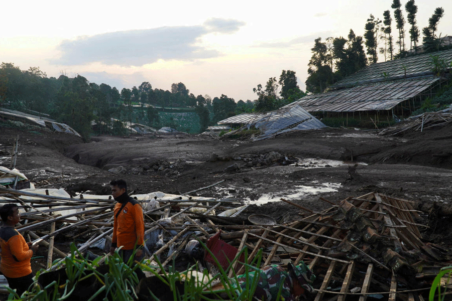 Indonesian rescue members stand near damage houses after a landslide hit Pasirlangu village, West Bandung