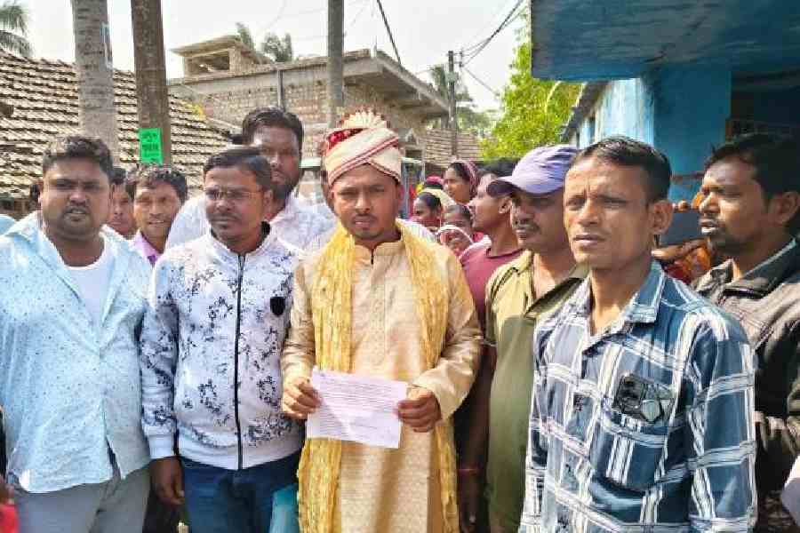 Anowar Hossain Khan, dressed in his wedding finery, waits at the hearing centre in Diamond Harbour on Tuesday. Picture by Mehaboob Gazi