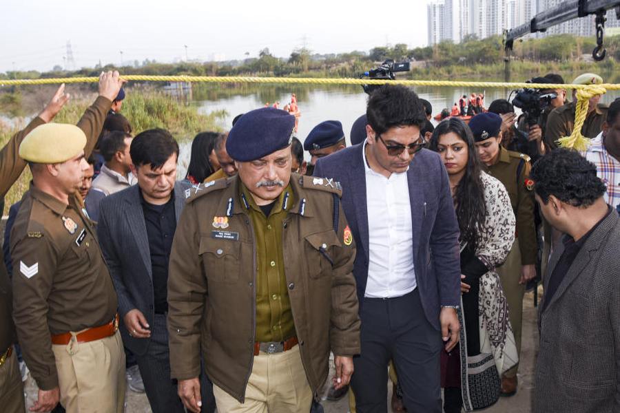 Police officials during a search operation at the site after a 27-year-old software engineer died, whose car had plunged into a water-filled pit at a construction site, in Noida, Tuesday, Jan. 20, 2026.