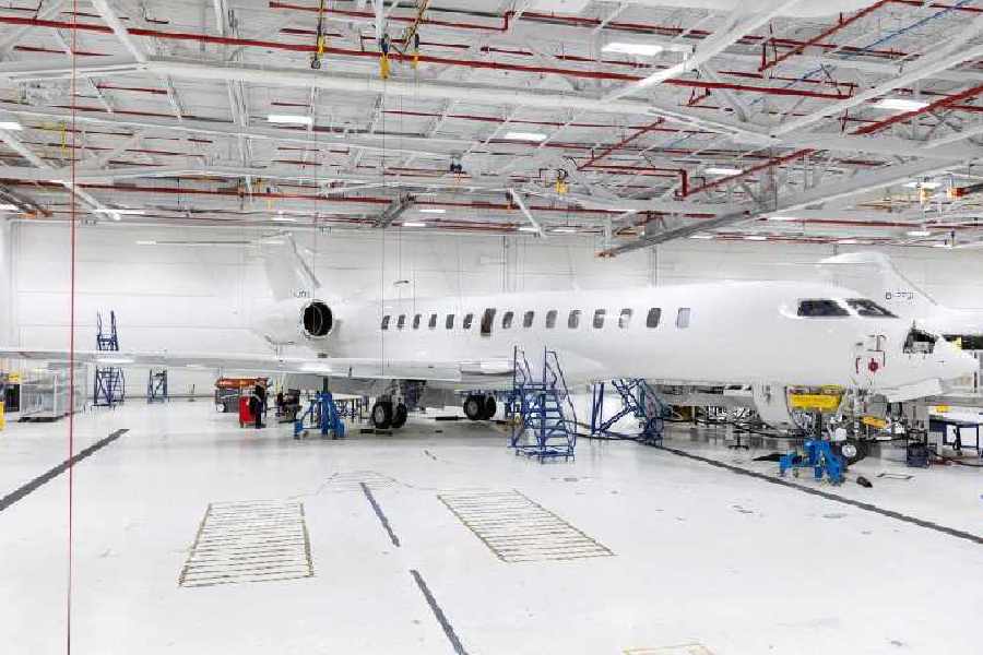 People stand next to a Bombardier Global 7500 aircraft at Bombardier's private jet completion center in Montreal, Canada