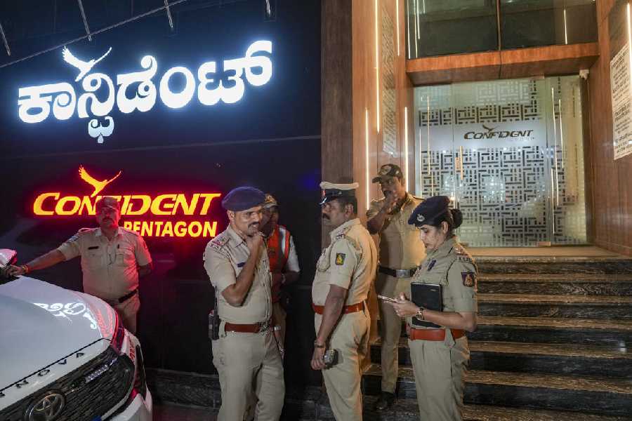 Police personnel stand guard outside Confident Group’s office building after the founder and chairman of the real estate firm C J Roy was found dead in the office, in Bengaluru