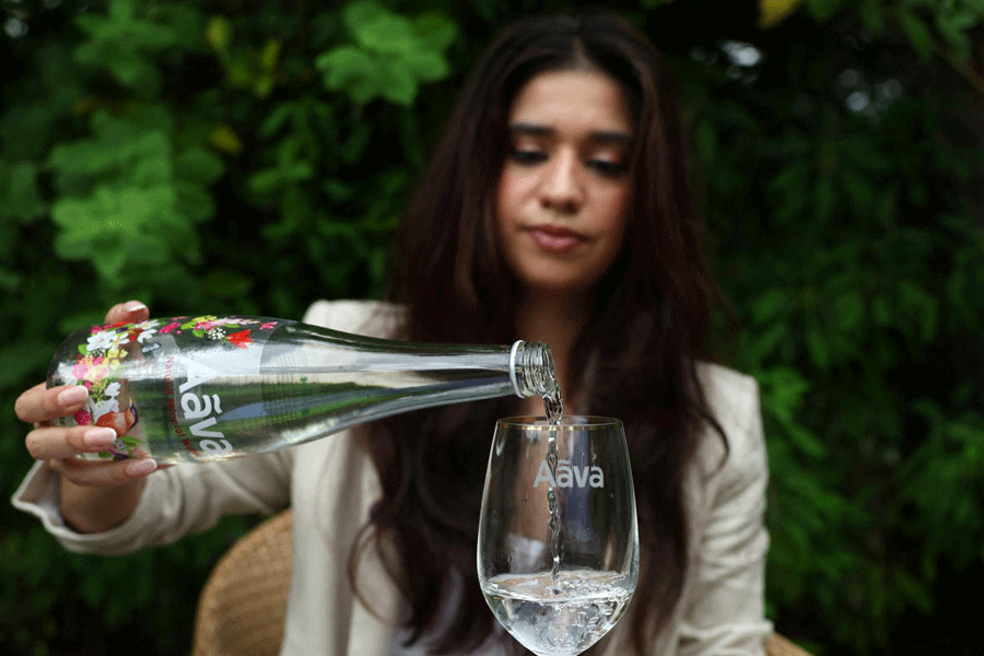 Avanti Mehta, India's youngest water sommelier, fills a glass with Aava Natural mineral water in Ahmedabad