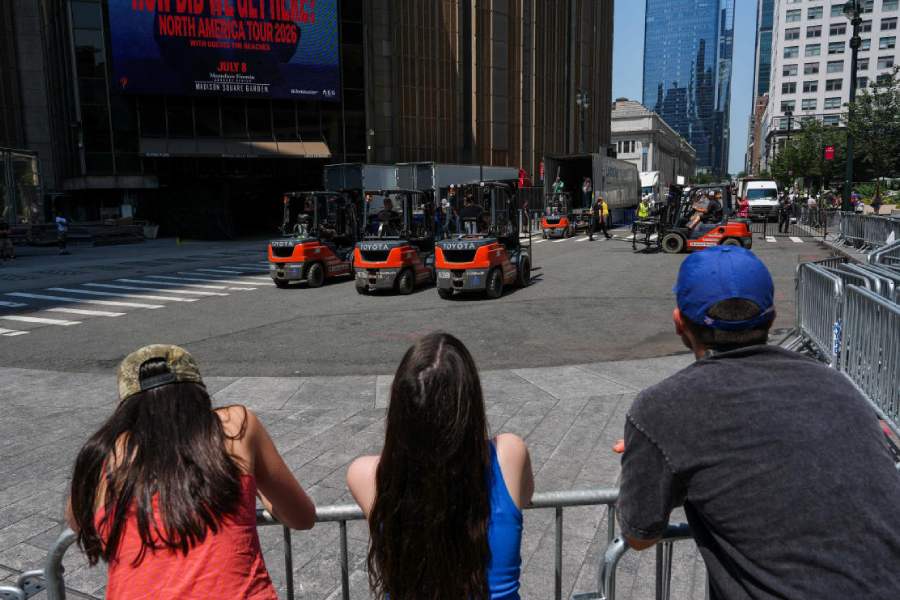 People watch as trucks are unloaded at Madison Square Garden, ahead of a reported wedding between Taylor Swift and Travis Kelce