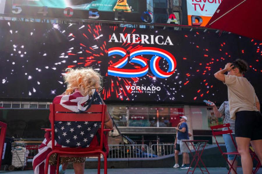 People at Times Square in New York City before a ball drops marking the stroke of midnight in Guam and the Northern Mariana Islands, the first US timezones to reach Independence Day.