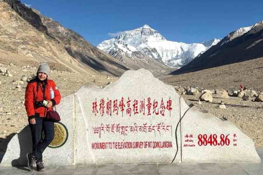 The writer with marker for Mount Everest with the peak in the background
