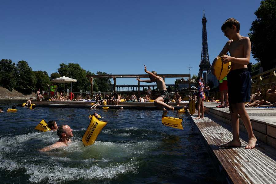 A person jumps into the River Seine at the Grenelle public bathing site, which is open to swimmers for the second year in the capital's historic waterway, with the Eiffel Tower in the background, in Paris, France, July 4, 2026.