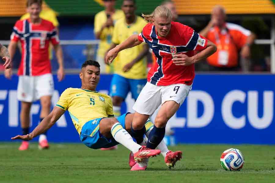 Brazil\'s Casemiro (5) falls as he and Norway\'s Erling Haaland (9) battle for the ball