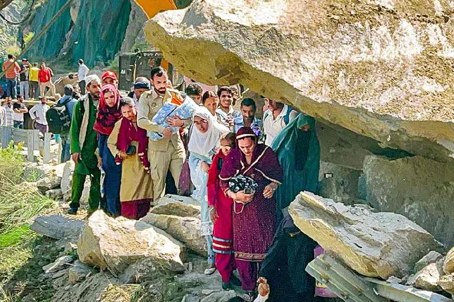 People negotiate a precarious stretch of the Doda-Kishtwar road following a landslide on May 2.