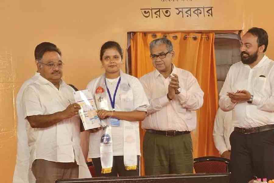 Samik Bhattacharya hands over a vaccination certificate to a girl as Sharadwat Mukherjee and Indranil Khan look on at Bidhannagar Subdivisional Hospital