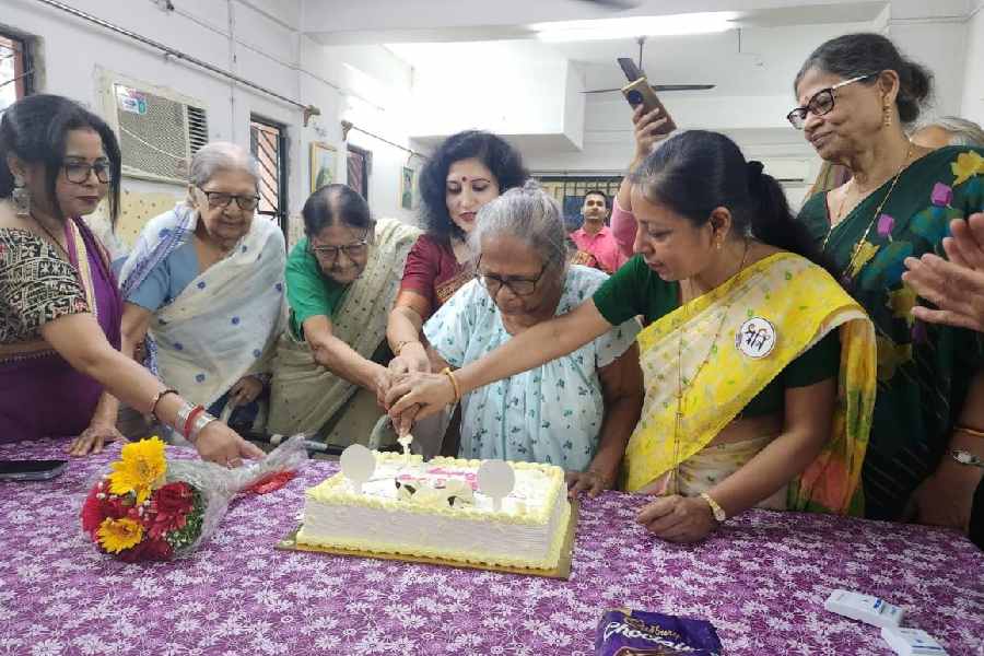 Elderly residents at Bairag cut the cake along with Dhwani members 