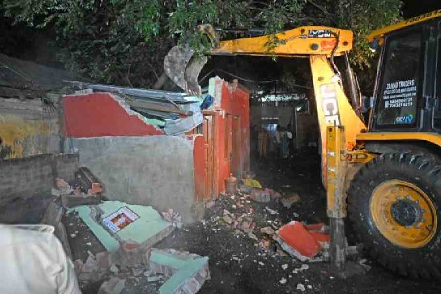 An earth mover demolishes a structure in Jadavpur on Monday night