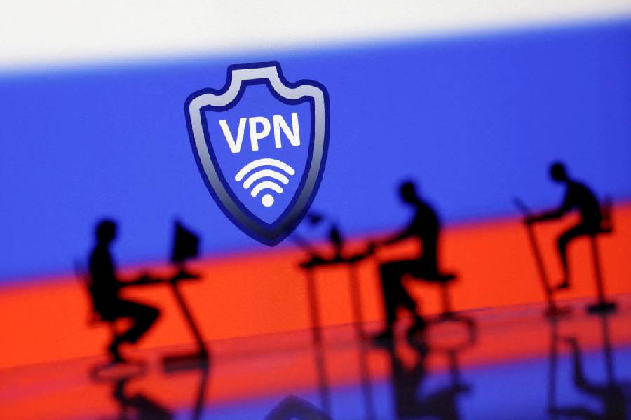 A VPN sign is seen in front of silhouetted miniatures of people with computers and the Russian flag in this illustration taken April 23, 2024.