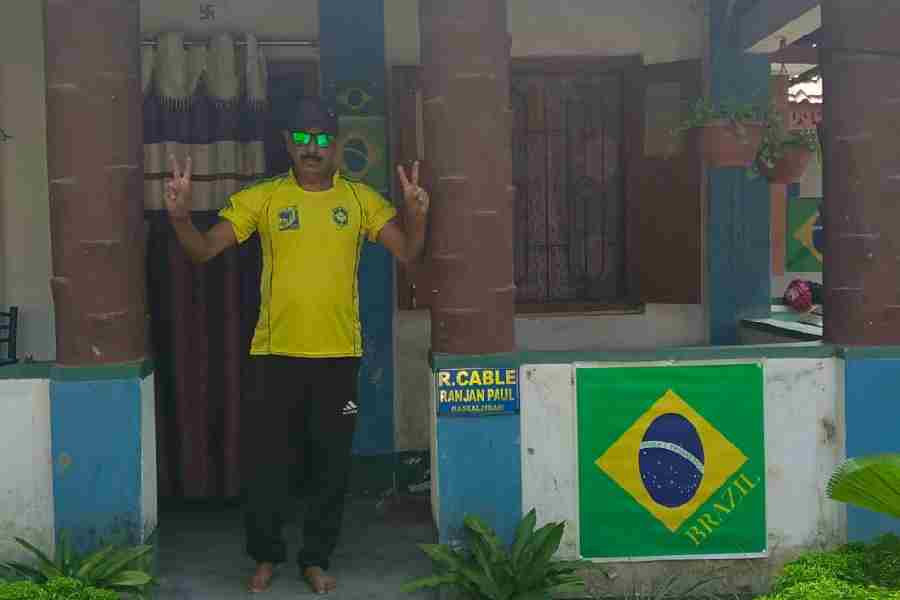 Ranjan Paul poses in front of his house