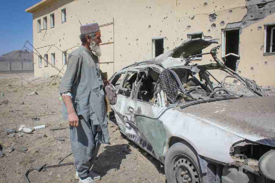 An Afghan man stands next to a damaged car following airstrikes, amid the conflict between Afghanistan and Pakistan, in Kandahar, Afghanistan, February 28, 2026.